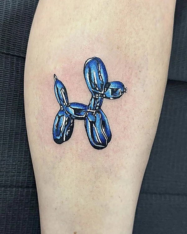 Perro globo azul cromado, pequeño y a color, en la pierna